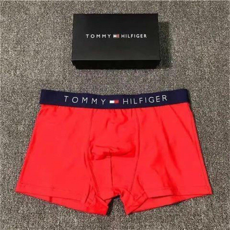 Red Tommy Hilfiger boxer briefs with a black box on a textured surface