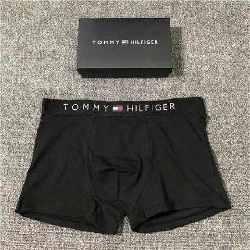 Black Tommy Hilfiger boxer briefs with a matching waistband on a textured surface.
