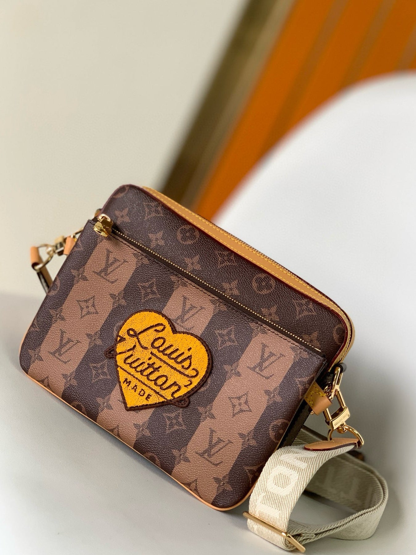 Louis Vuitton handbag with monogram pattern on a neutral background