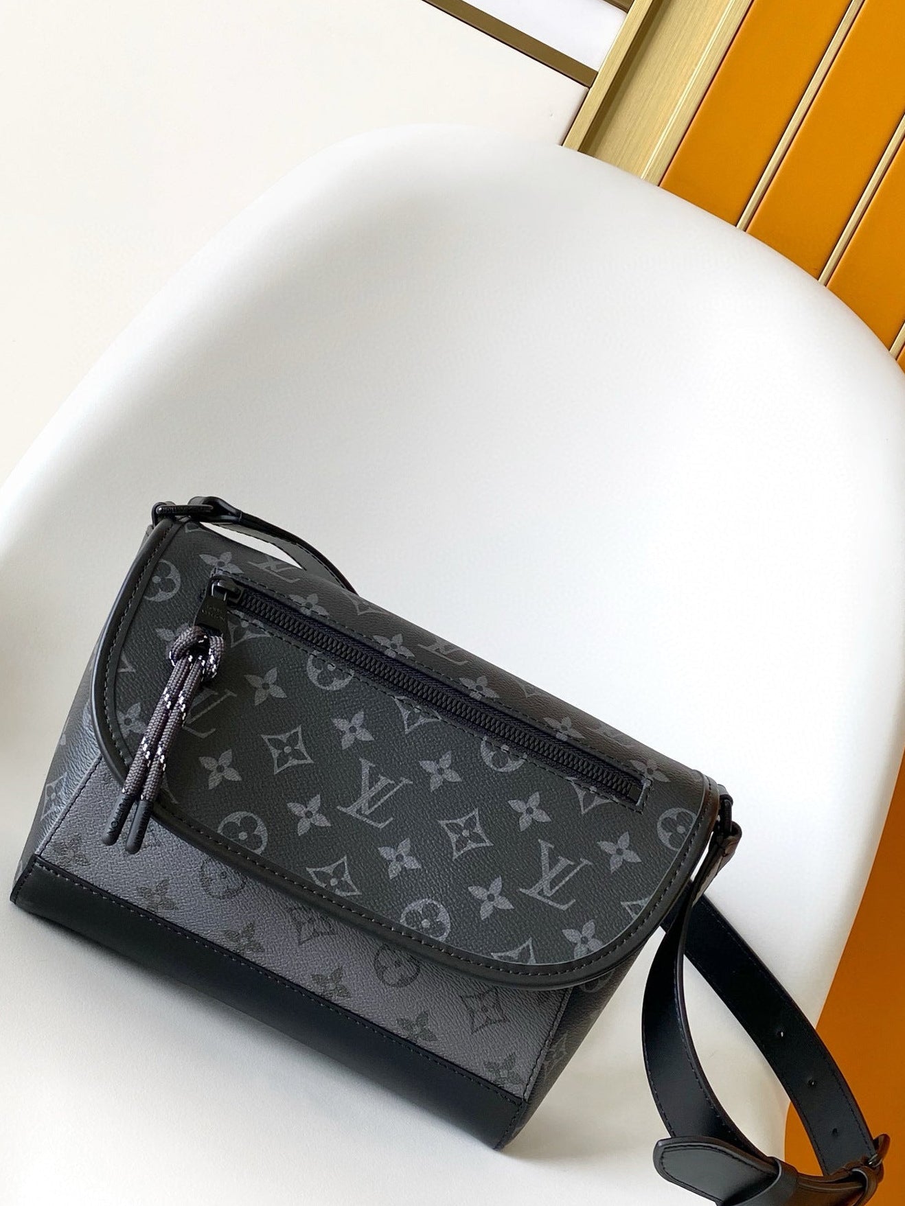 Black handbag with brand logo pattern on a white surface