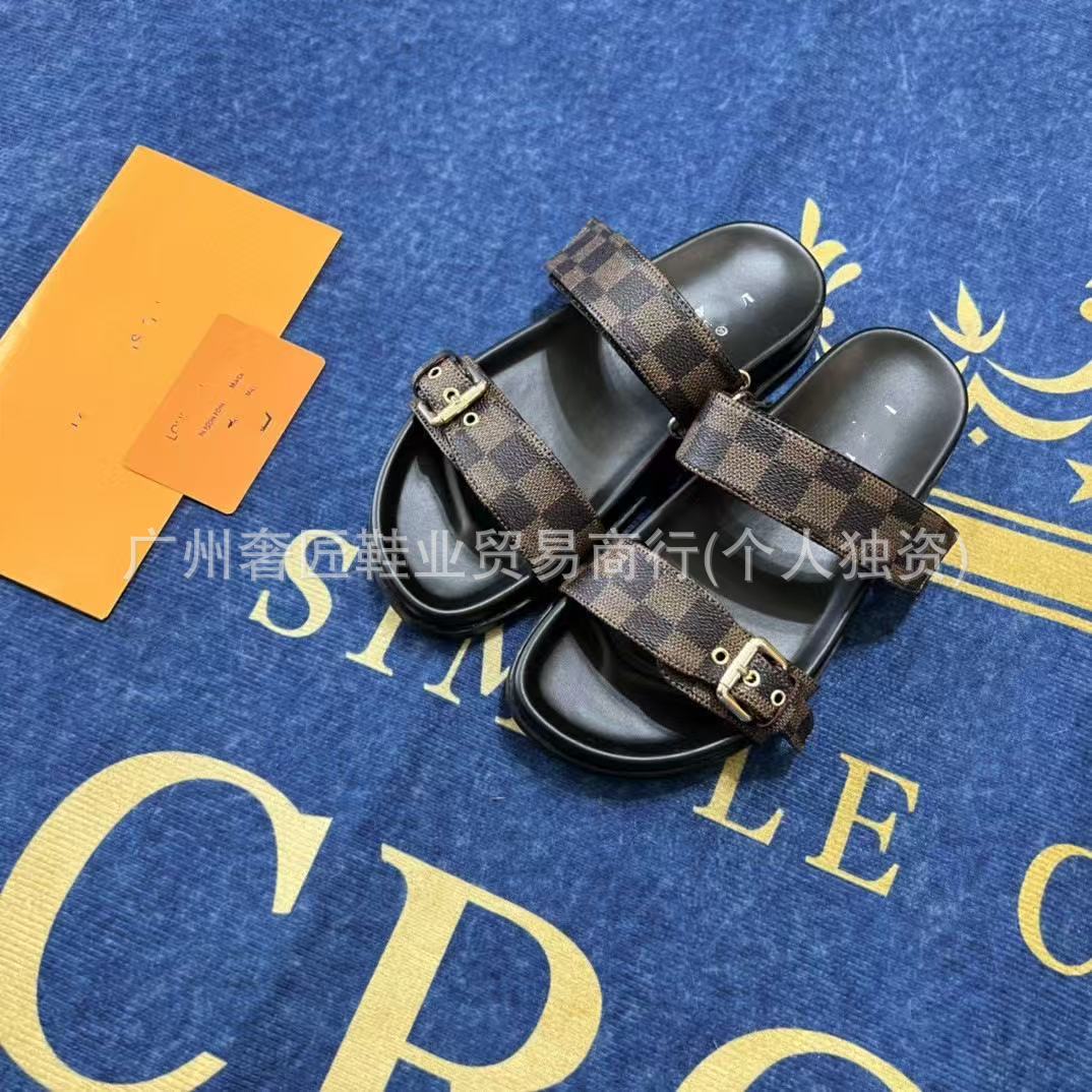 Pair of checkered slide sandals on a blue surface with gold text