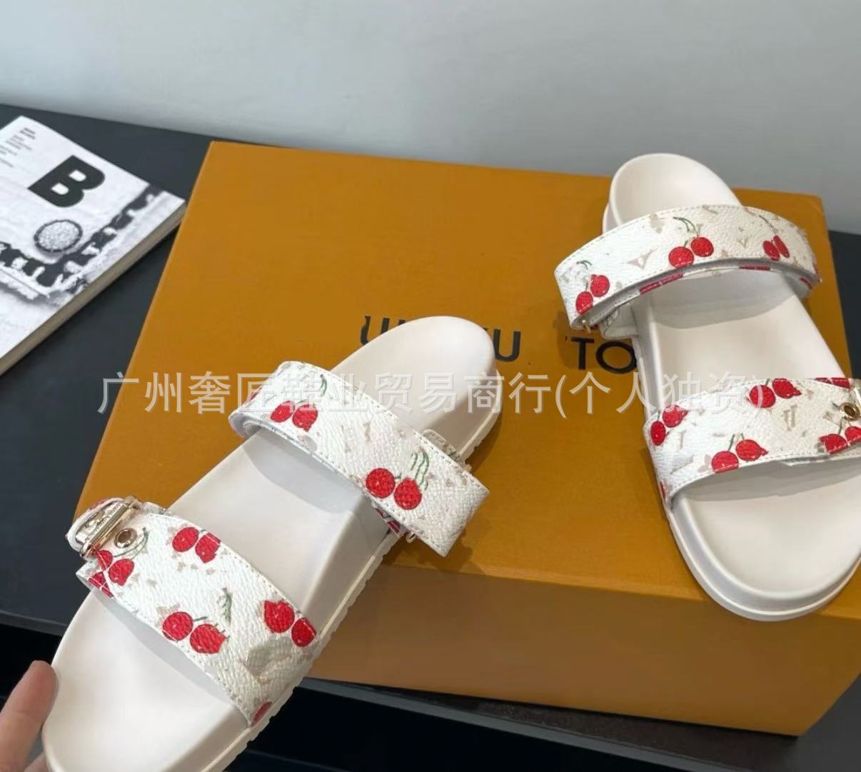 White sandals with red cherry design on a yellow box