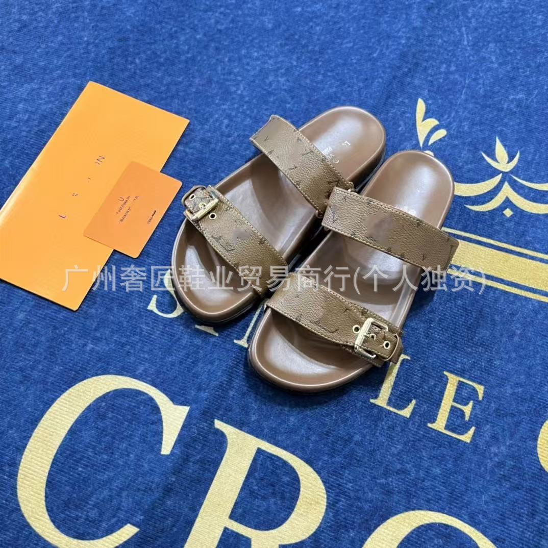 Brown sandals with gold buckles on a blue surface with yellow text