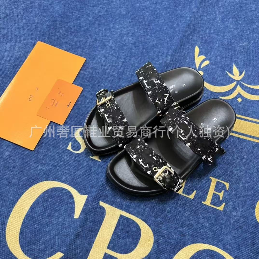 Black sandals with decorative straps on a blue surface with gold text