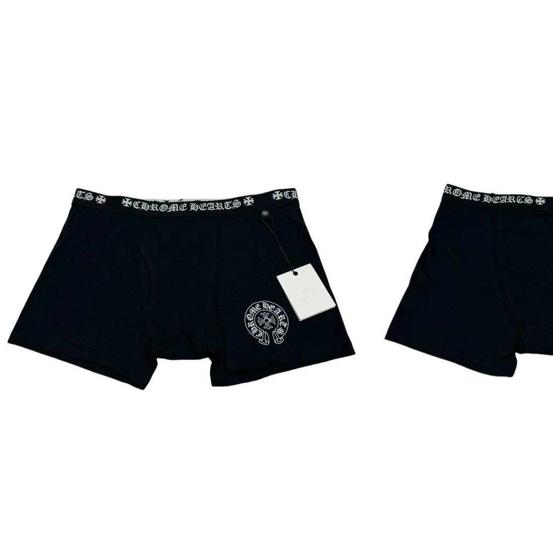 Black boxer briefs with a white patterned elastic waistband and a circular logo patch on the left leg, shown on a white background with a hangtag attached.