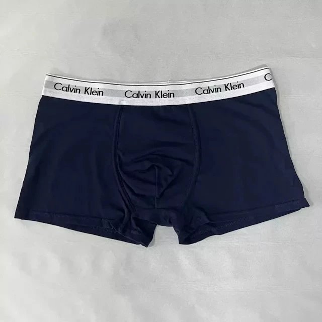 Navy Calvin Klein boxer briefs on a light gray background