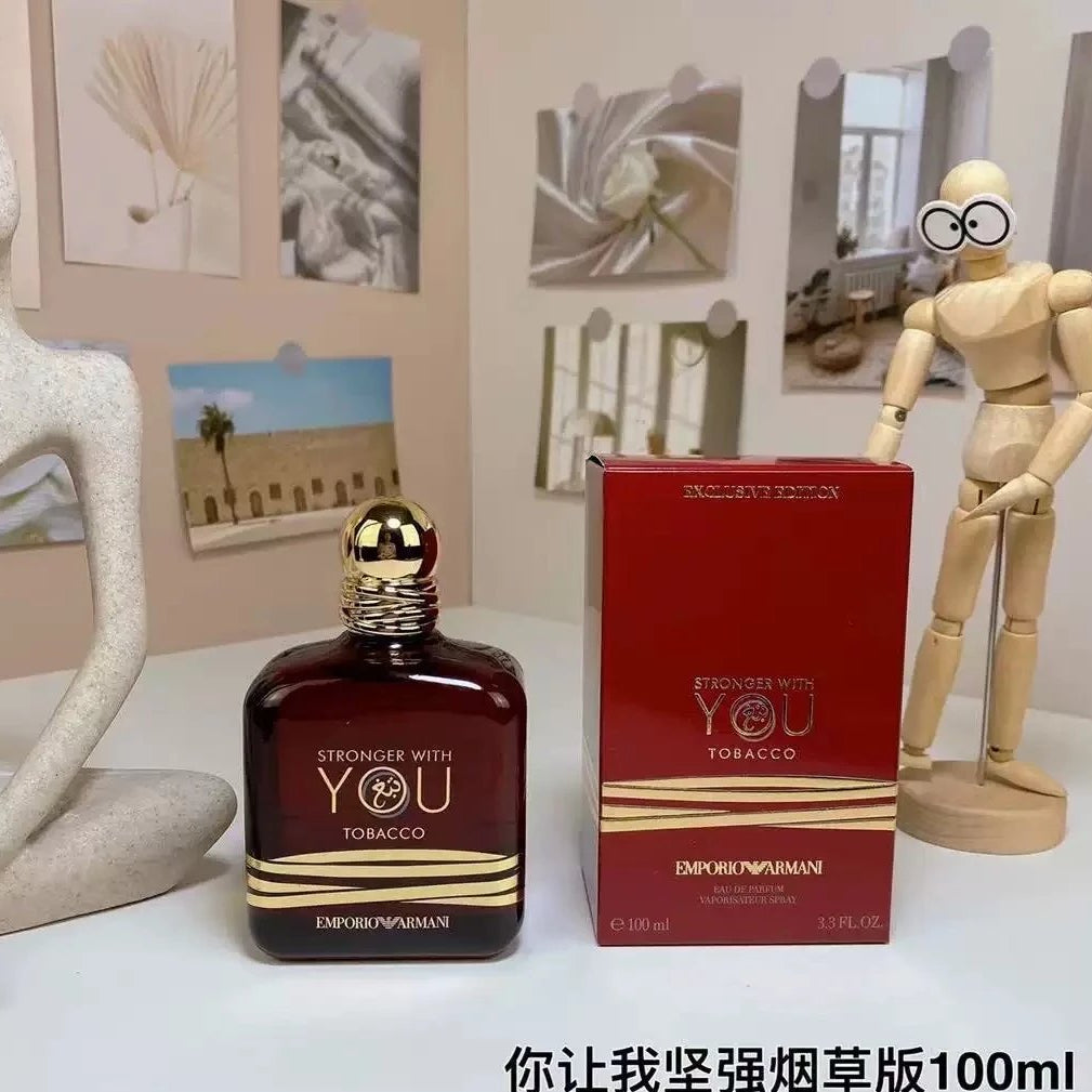 Emporio Armani cologne bottle and packaging on a table with decorative items.