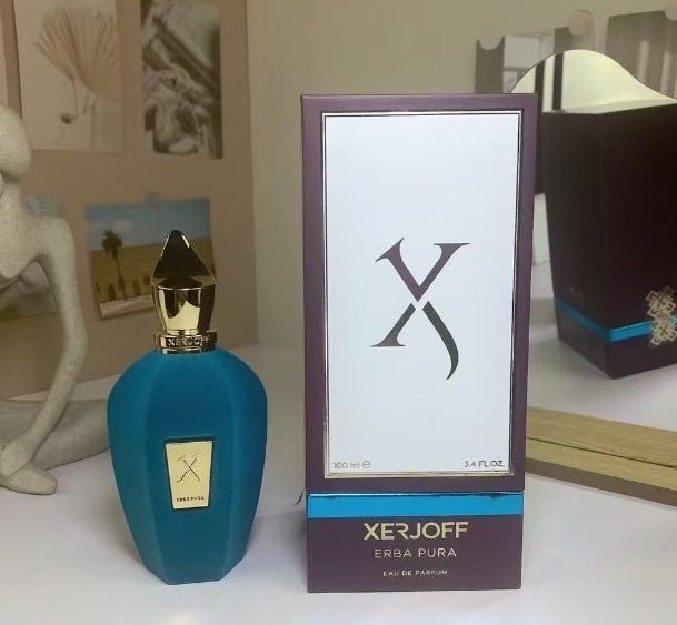 Xerjoff Erba Pura perfume bottle and packaging on a surface with decorative items in the background.