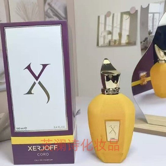 Yellow perfume bottle with gold cap and Xerjoff packaging on a white surface.